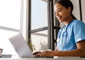 A vet studying a veterinary certificate course on a laptop