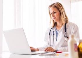 A vet sits at a computer taking an online certificate course