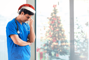 A vet wearing a Christmas hat looks stressed