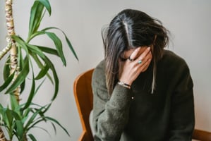 A vet sits with her head in her hands after making a veterinary mistake